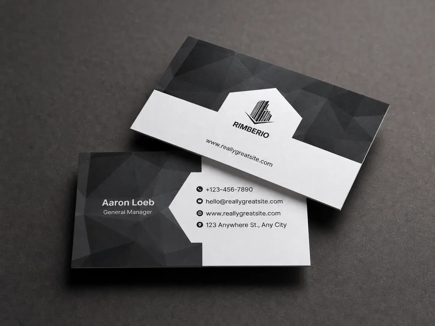 A black and white uncoated business card at an angle on a dark surface