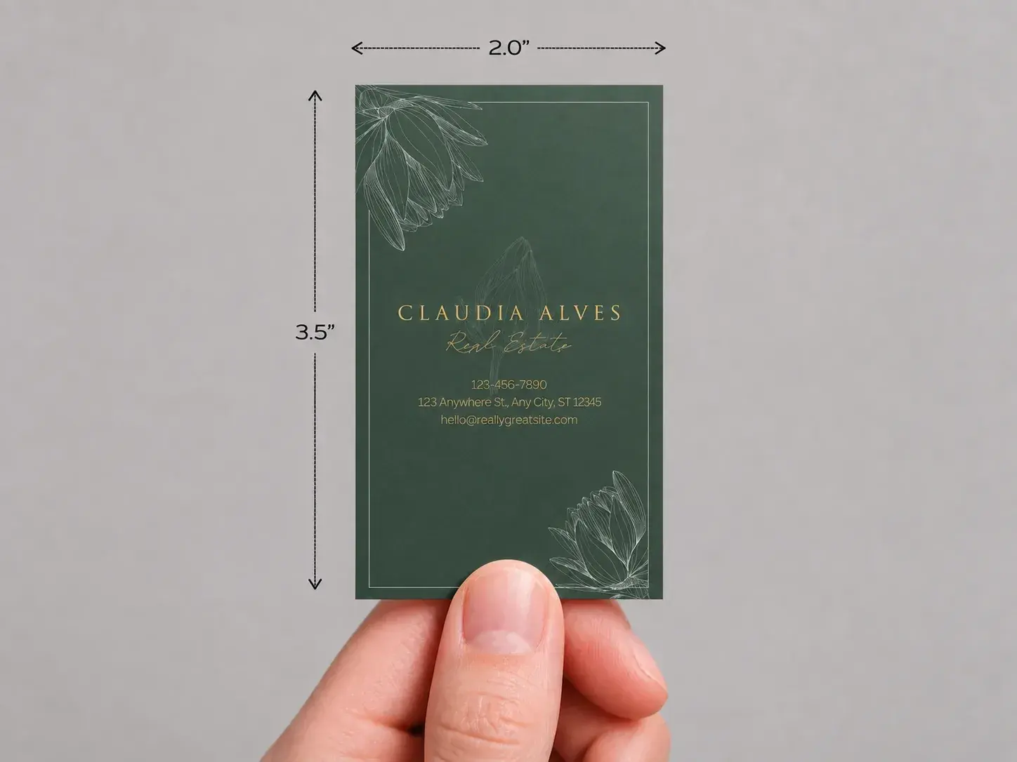 A hand holding an upright dark green soft-touch card, marked 2 × 3.5 in
