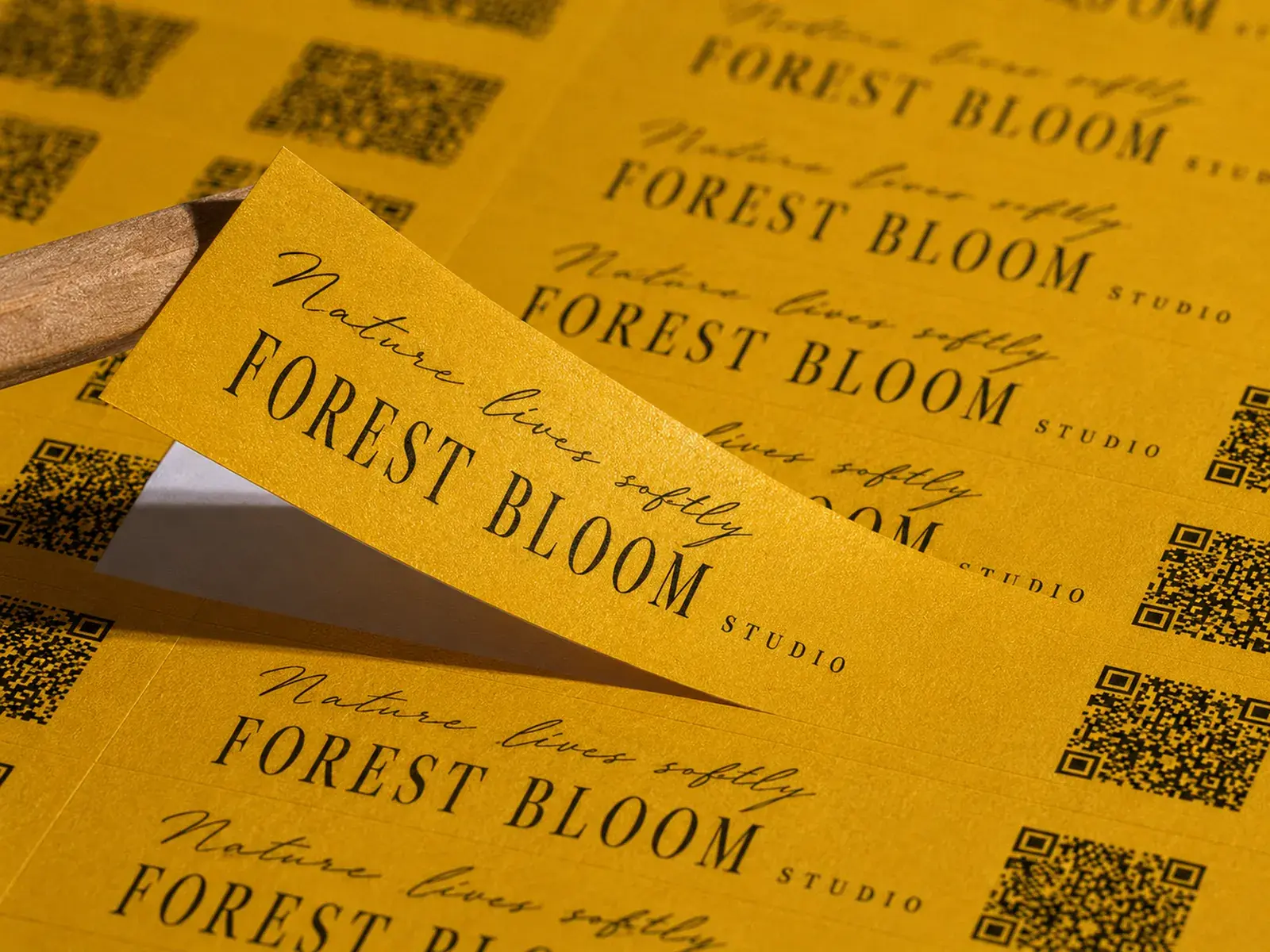 A sheet of golden shimmer paper labels, one lifted with a wooden stick