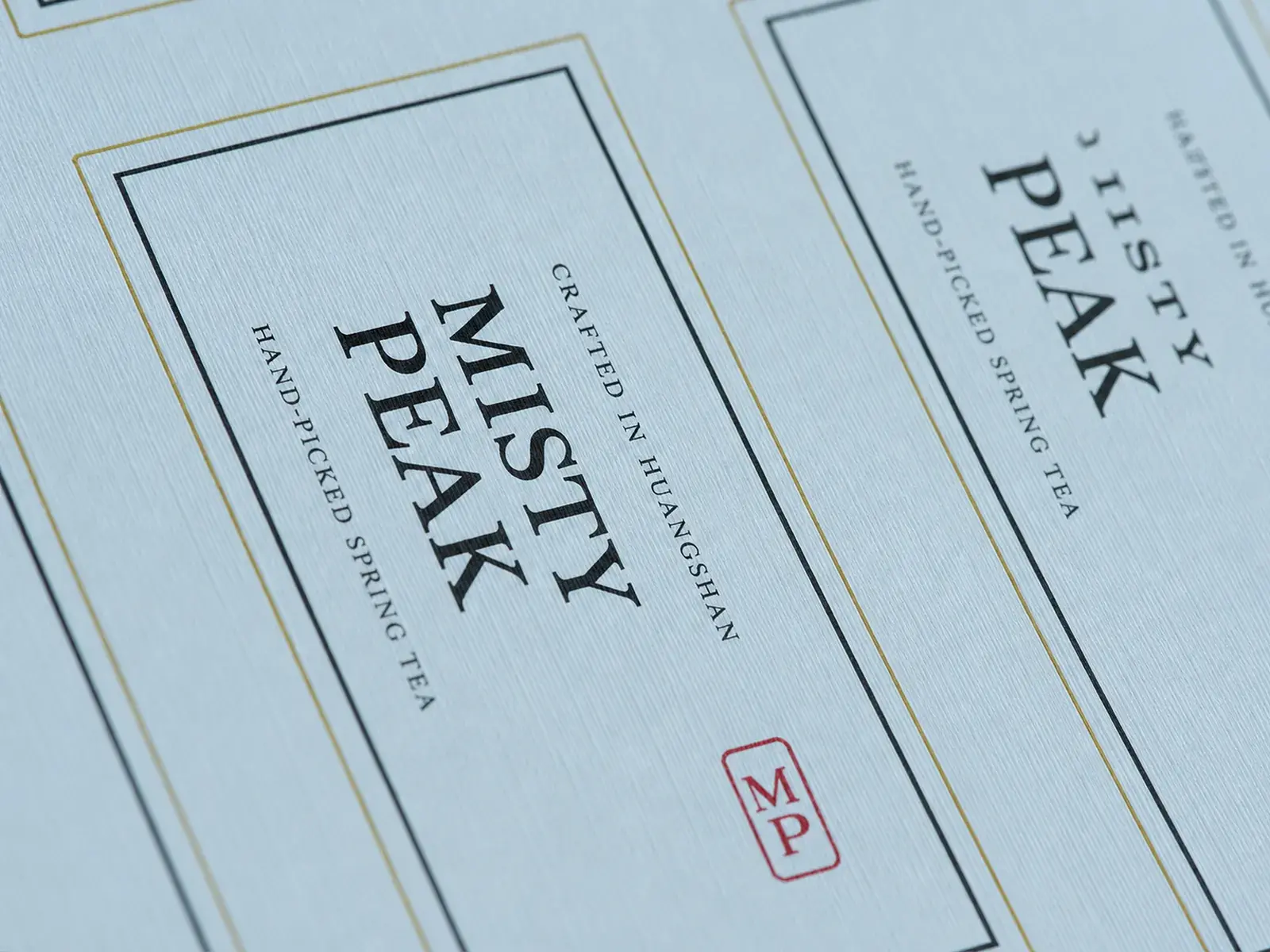 Close-up of a sheet of rectangular tea labels on linen-textured paper