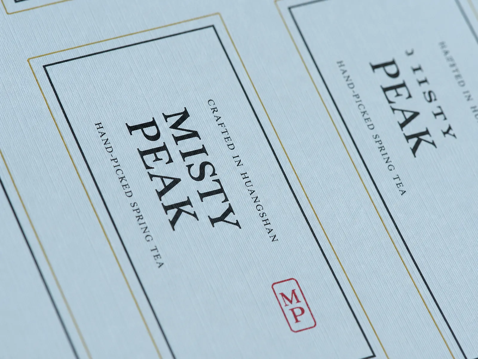 Close-up of a sheet of rectangular tea labels on linen-textured paper