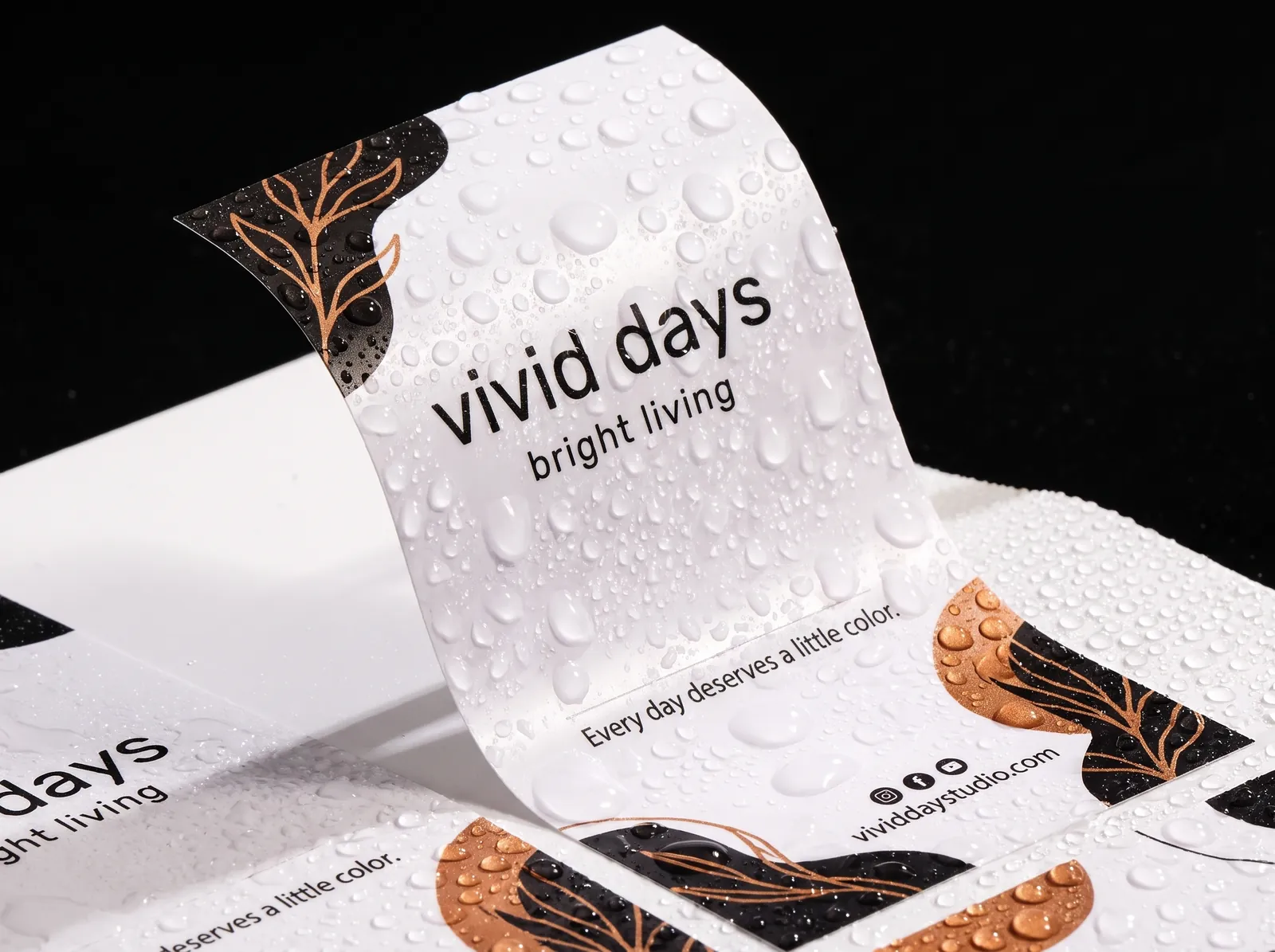 A sheet of white film labels covered in water droplets, one peeled up